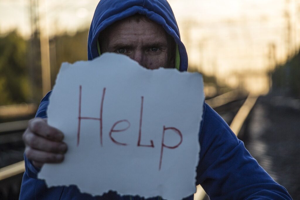 helpと書かれた紙を持った男性