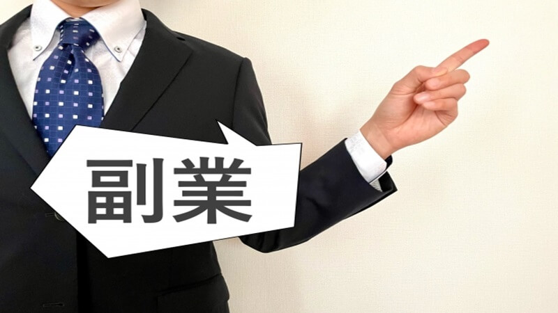 男性ビジネスパーソンが指差しをして副業を紹介する様子
