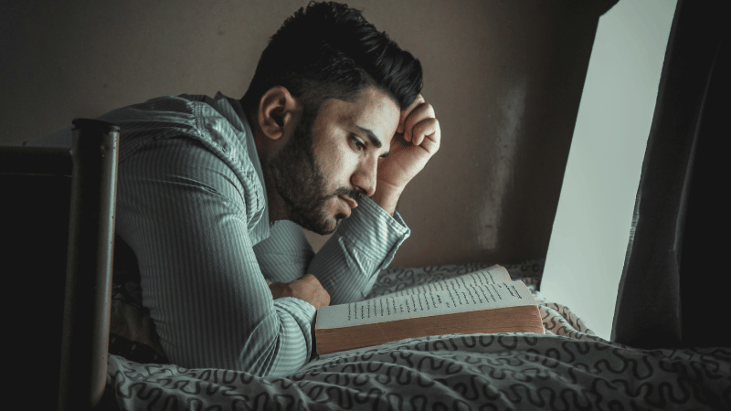 うつむいて本を読む男性