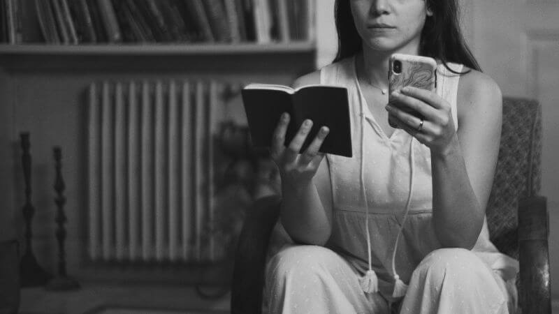 ノートとスマホを持つ女性